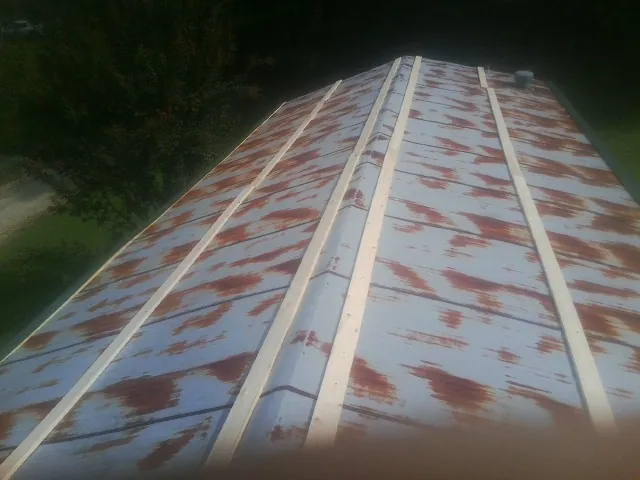 Rusted metal roof panels with new wood purlins before replacement — Storm Damage Roof Repair in South Mills by Roofing Brothers