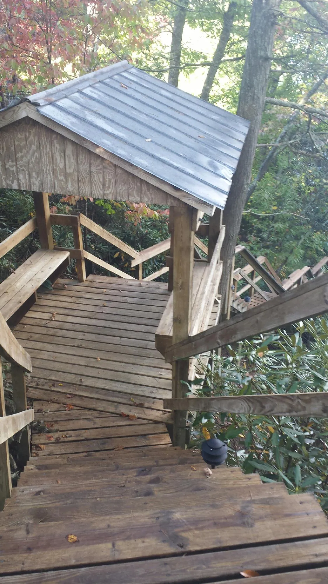 Metal roofed shelter over wooden steps on a wooded walkway — Skylight Repair & Installation work by our crew in South Mills